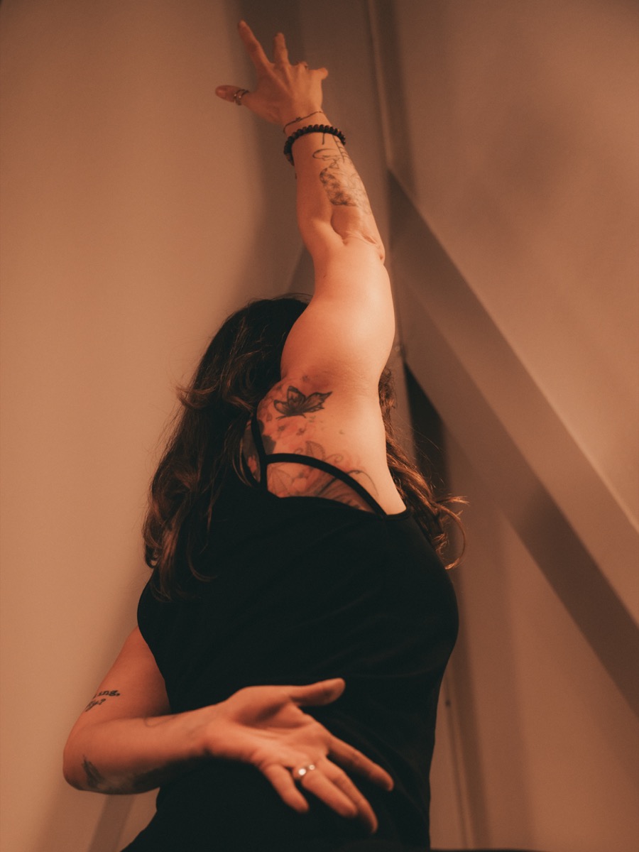 Gabriele streckt in einer Yogahaltung den Arm nach oben